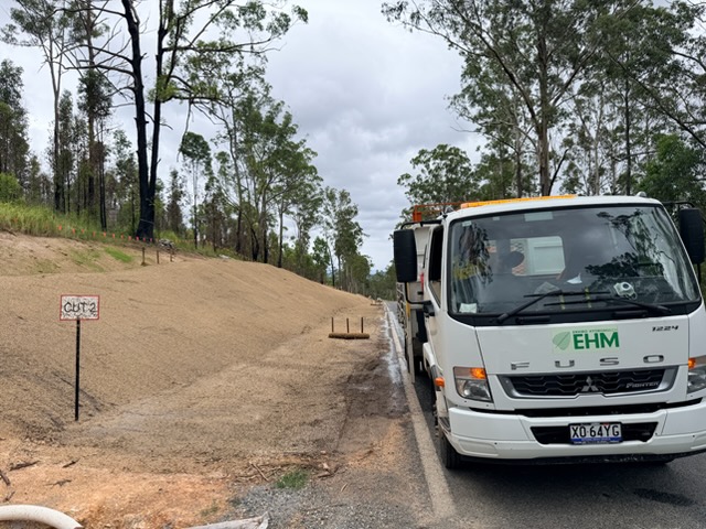 EHM truck applying hydromulch to road embankment
